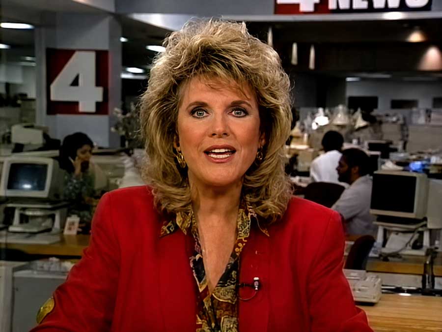 Kelly Lange on the KNBC Channel 4 News anchor desk in Los Angeles, with the newsroom visible behind her